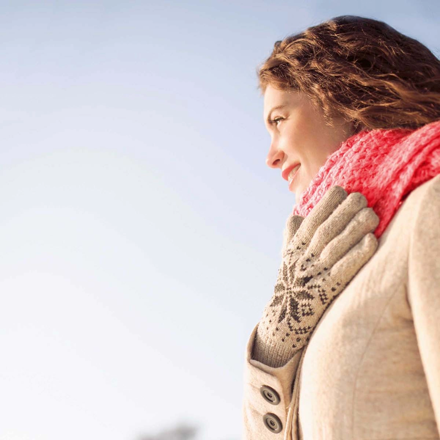 Eine Frau mit einem Schal steht in einer Winterlandschaft
