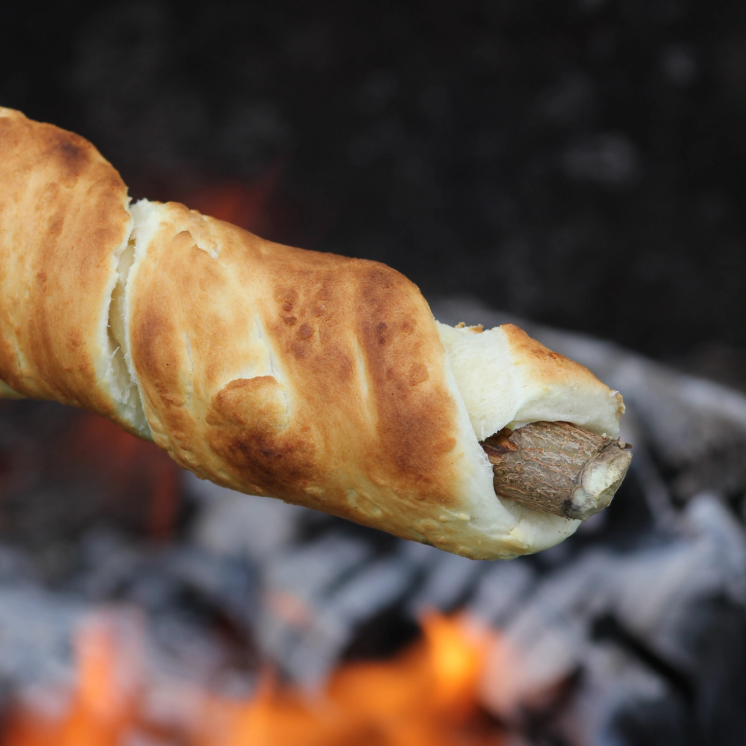 Schlangenbrot beim Grillieren über der Glut