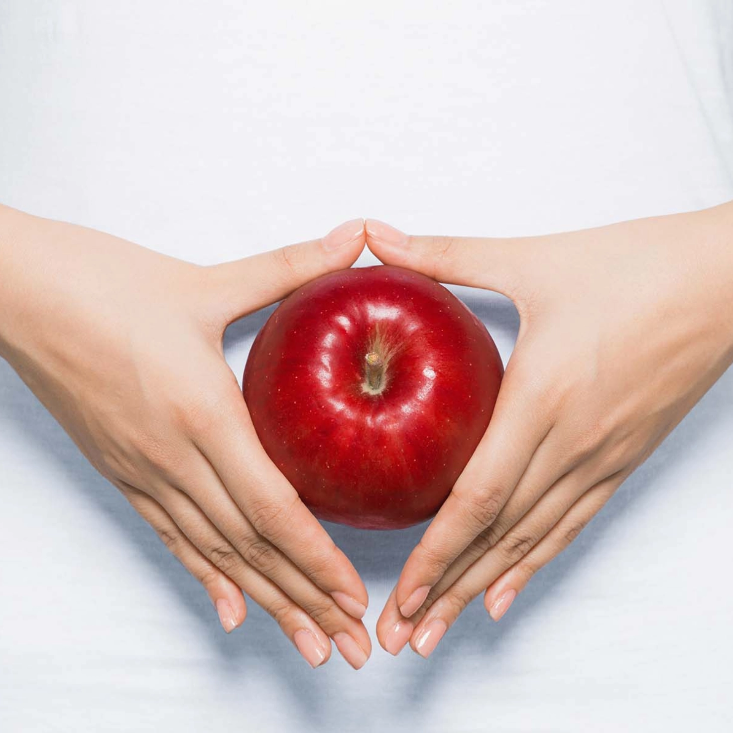 Une femme tient une pomme devant son ventre