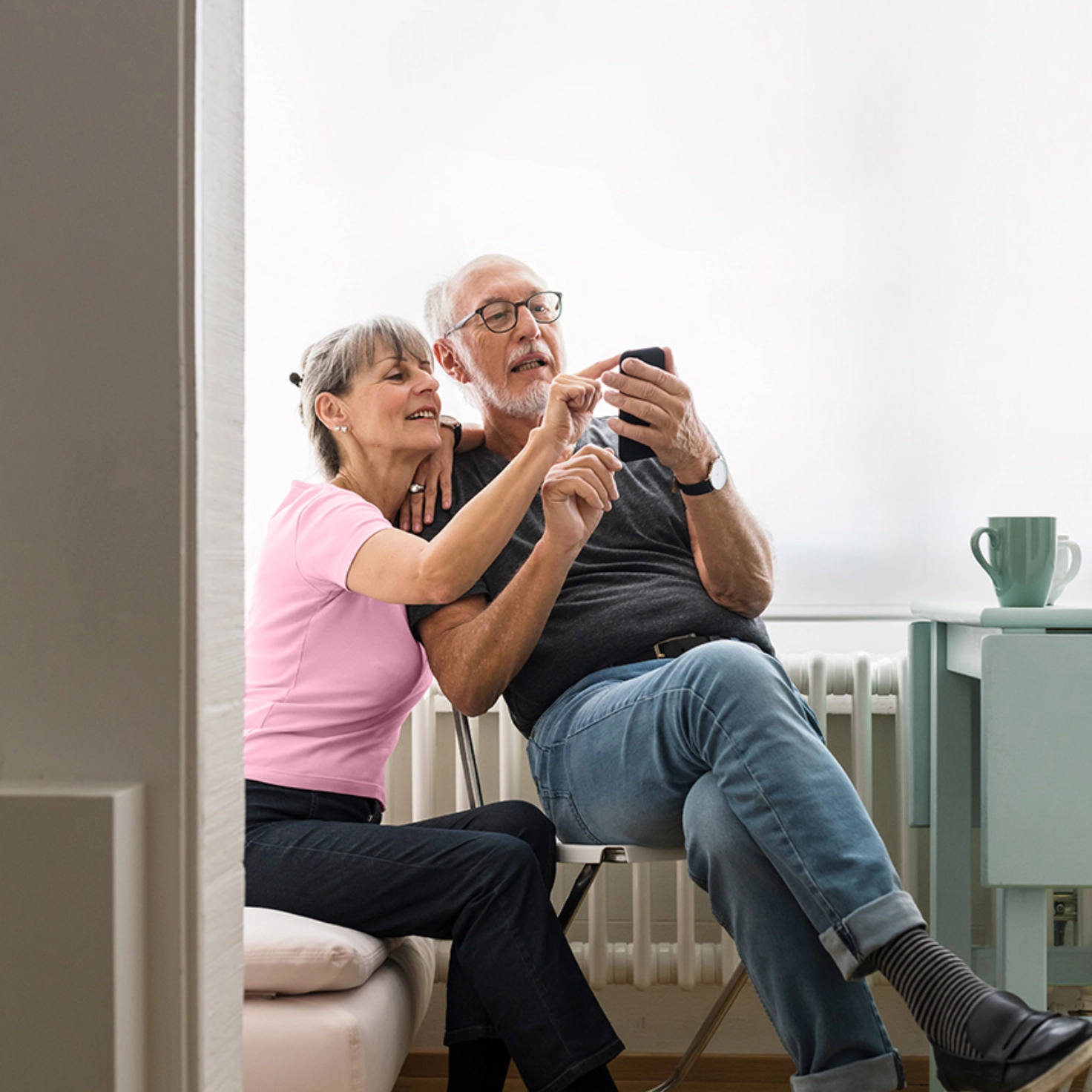 A man sits on the sofa and looks at his mail.