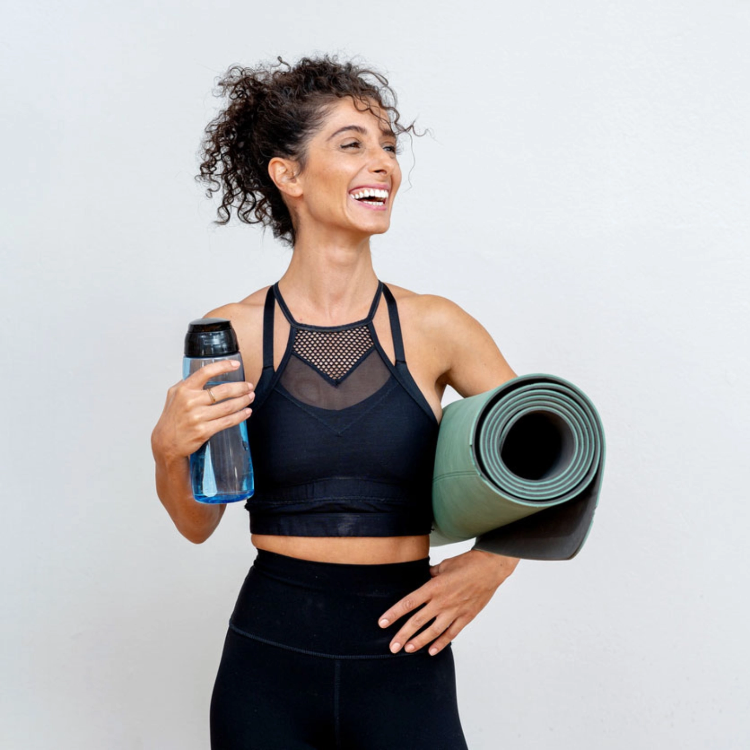 Frau mit Fitessmatte und Trinkflasche