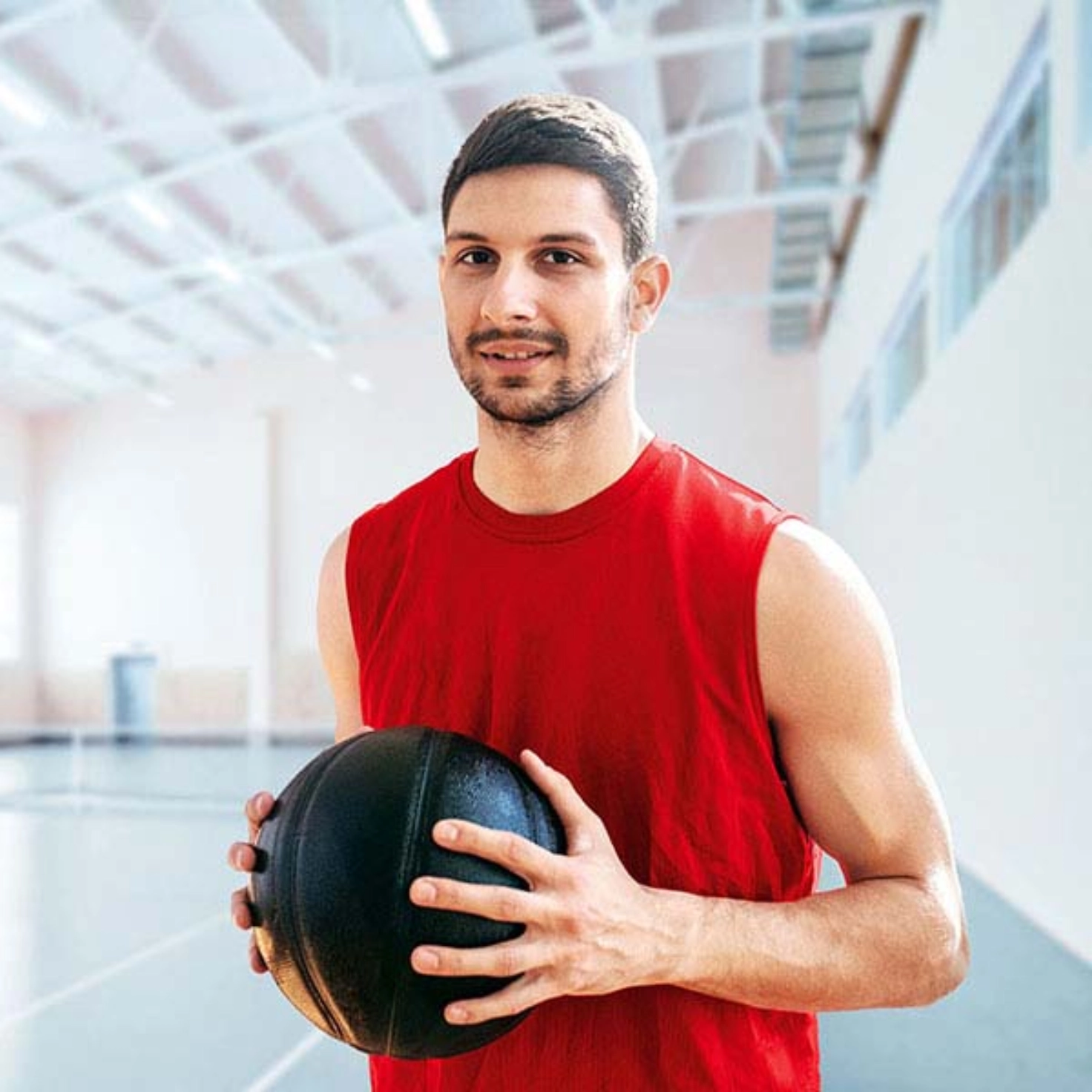 Man in gym holding basketball in his hands