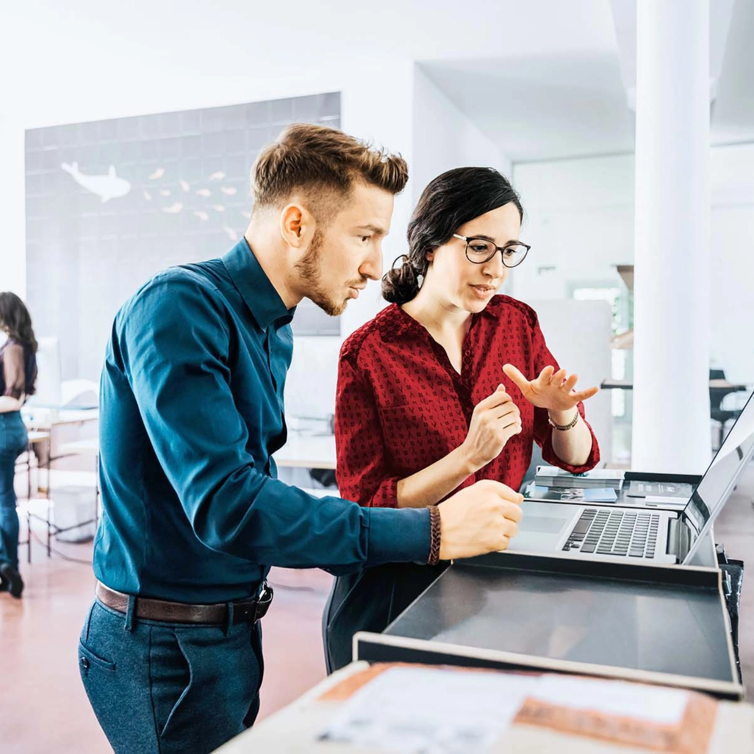 Informatiker und Informatikerin diskutieren am Schreibtisch