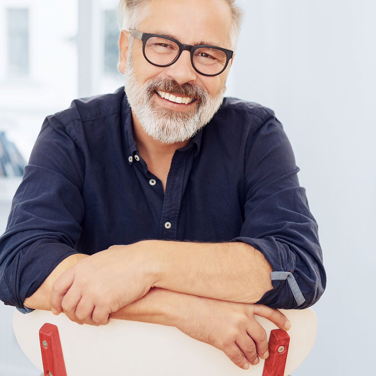 Man with glasses sitting on a chair