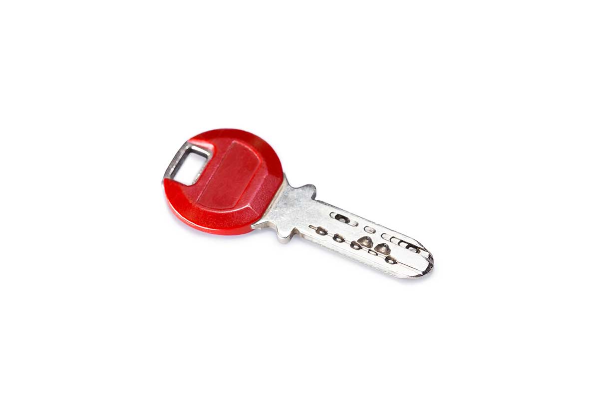 Une clé de voiture ou d'appartement sur un fond neutre.